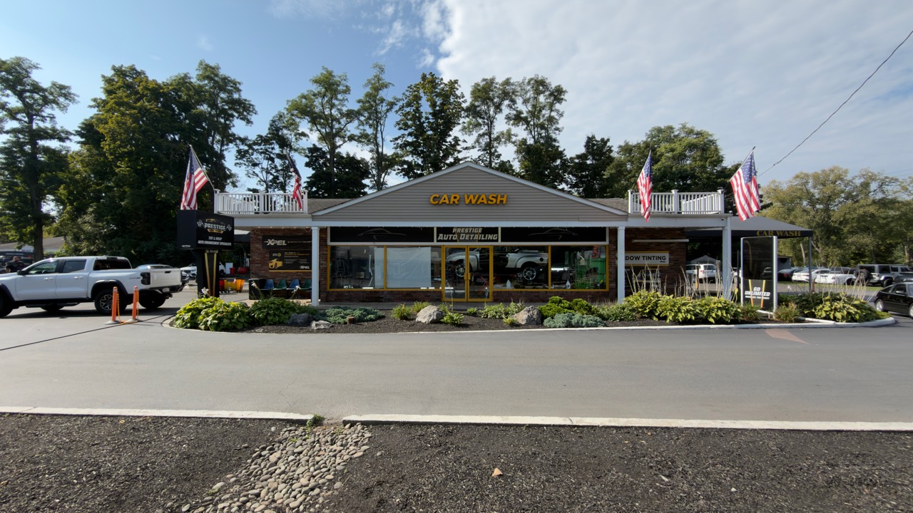 The current Prestige Car Wash storefront in Hopewell Junction, with yellow Car Wash signage and American flags